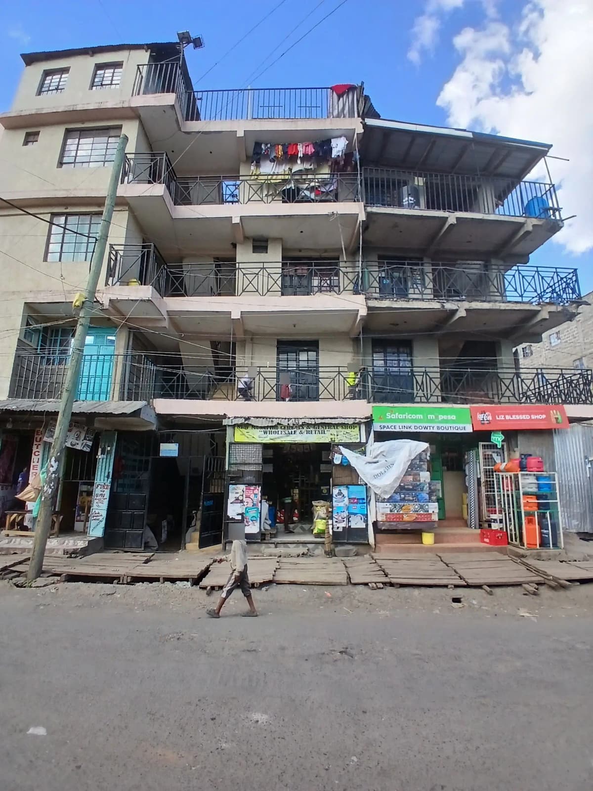 Multi-story residential building with ground-floor commercial shops