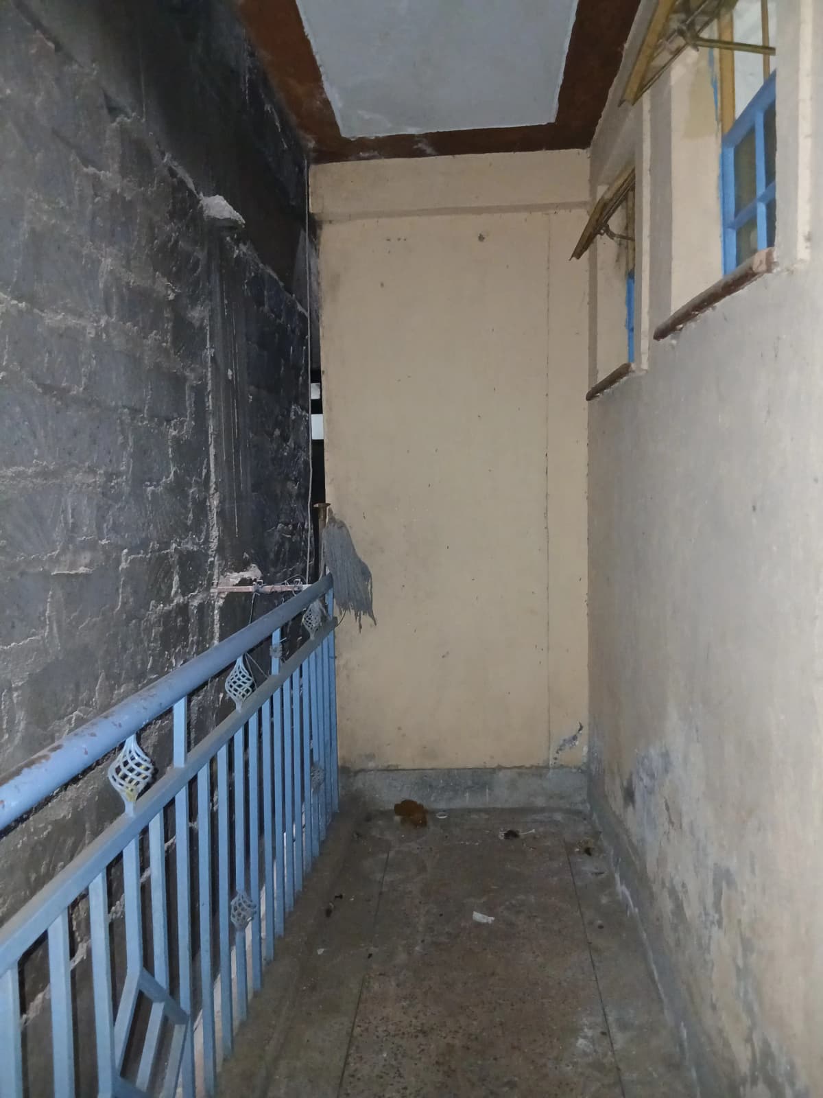 Narrow corridor with blue railing and skylight window