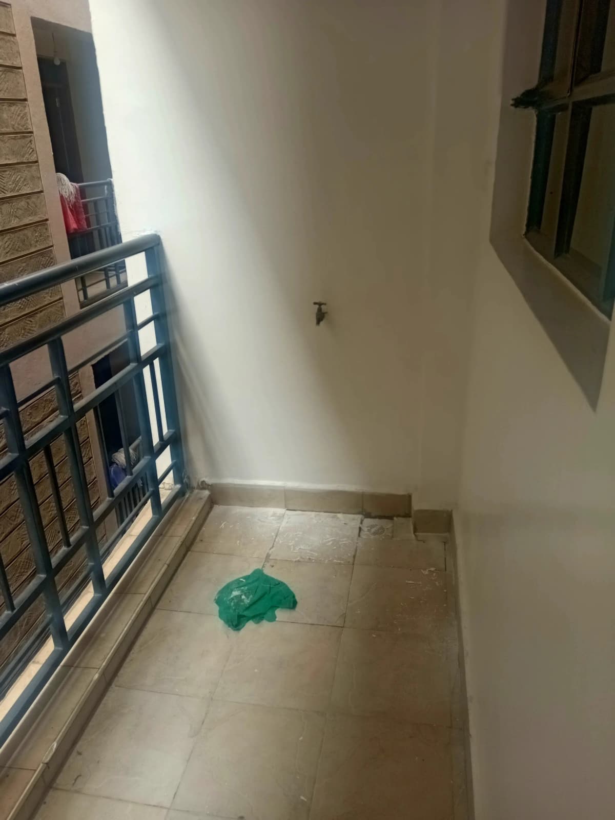 Narrow balcony with metal railing and tiled flooring