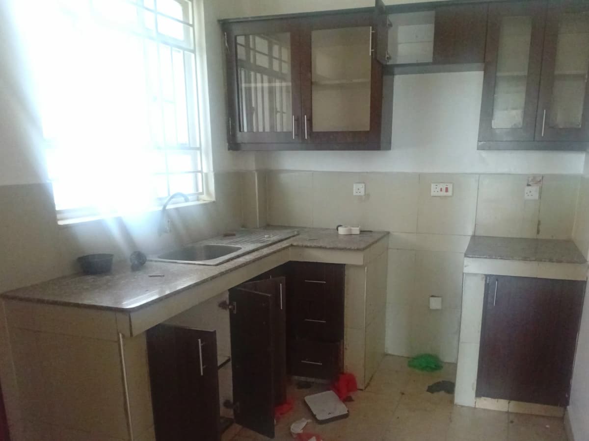 Compact kitchen with dark wood cabinets and stainless steel countertop
