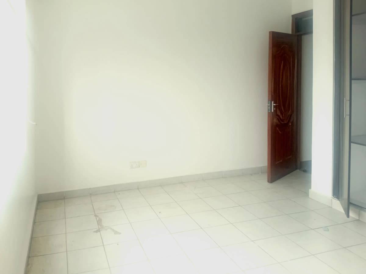 Empty living space with tiled floor and red door