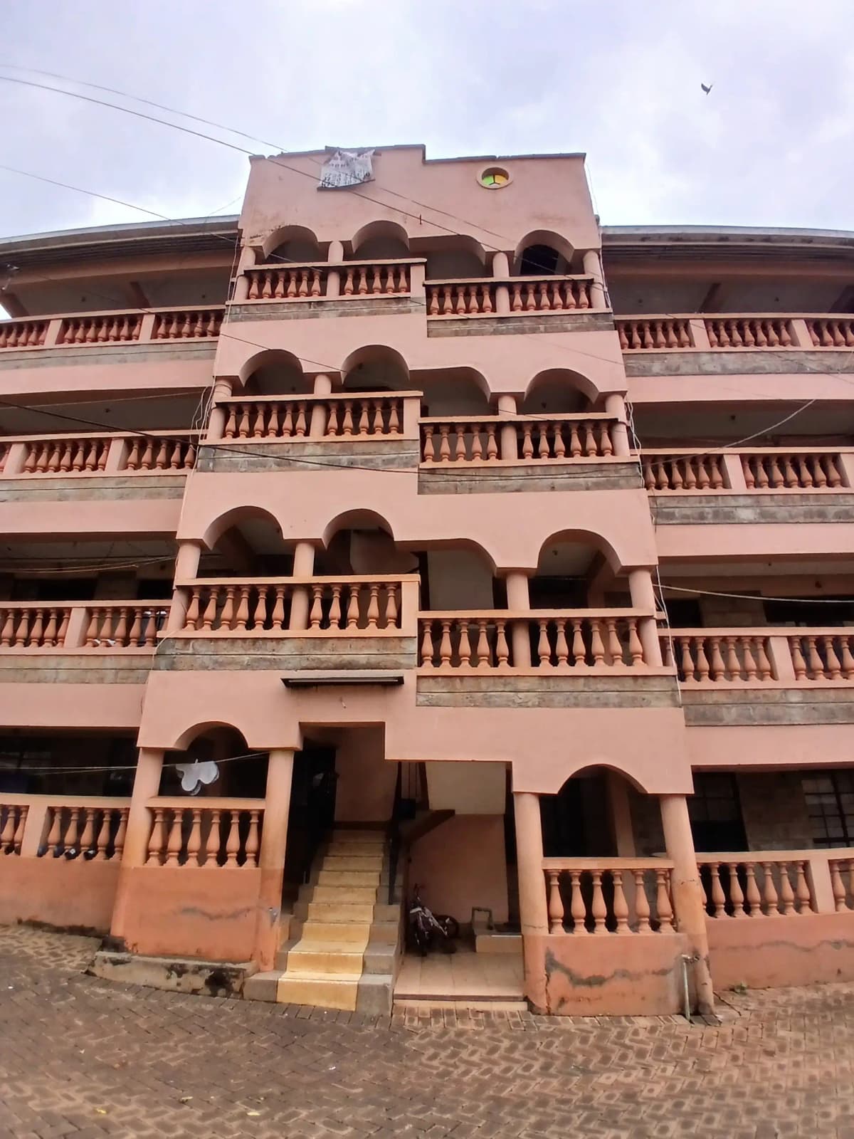 Terracotta building facade with ornate louvers and balconies