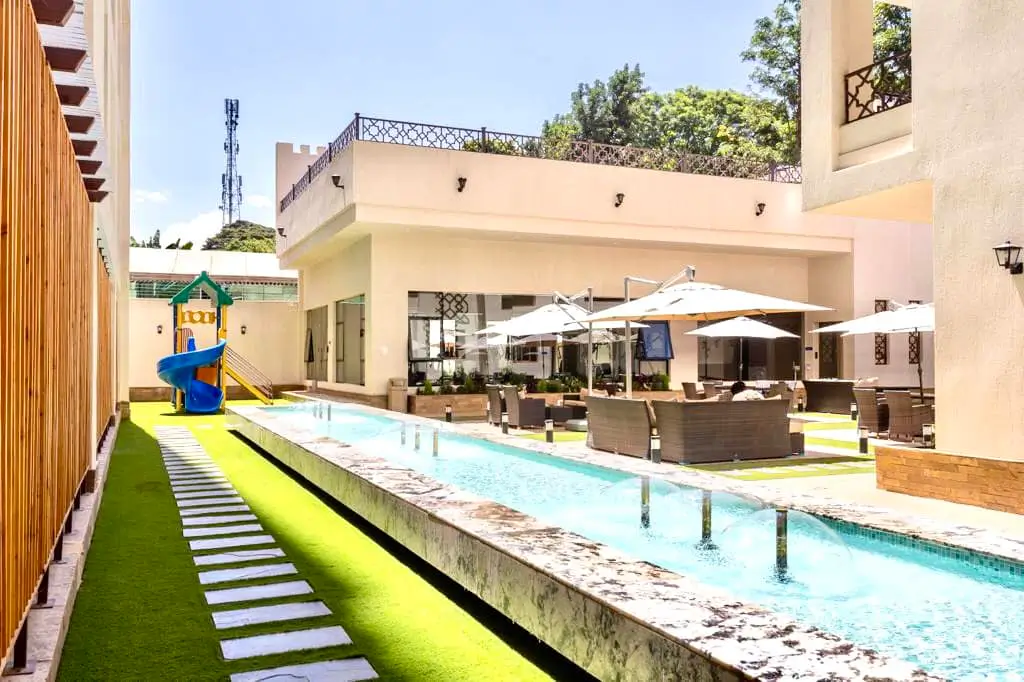 Resort-style swimming pool with loungers and manicured lawn