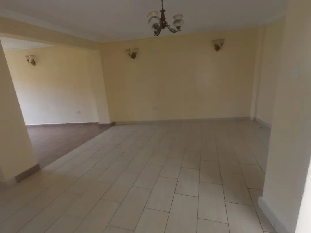 Empty living room with neutral tile flooring and pendant light