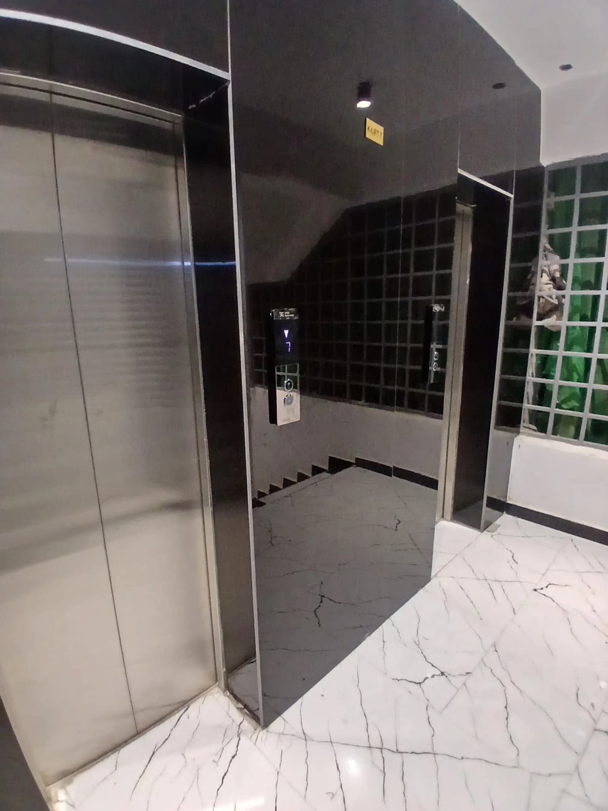 Modern bathroom with black tiled shower enclosure and marble flooring