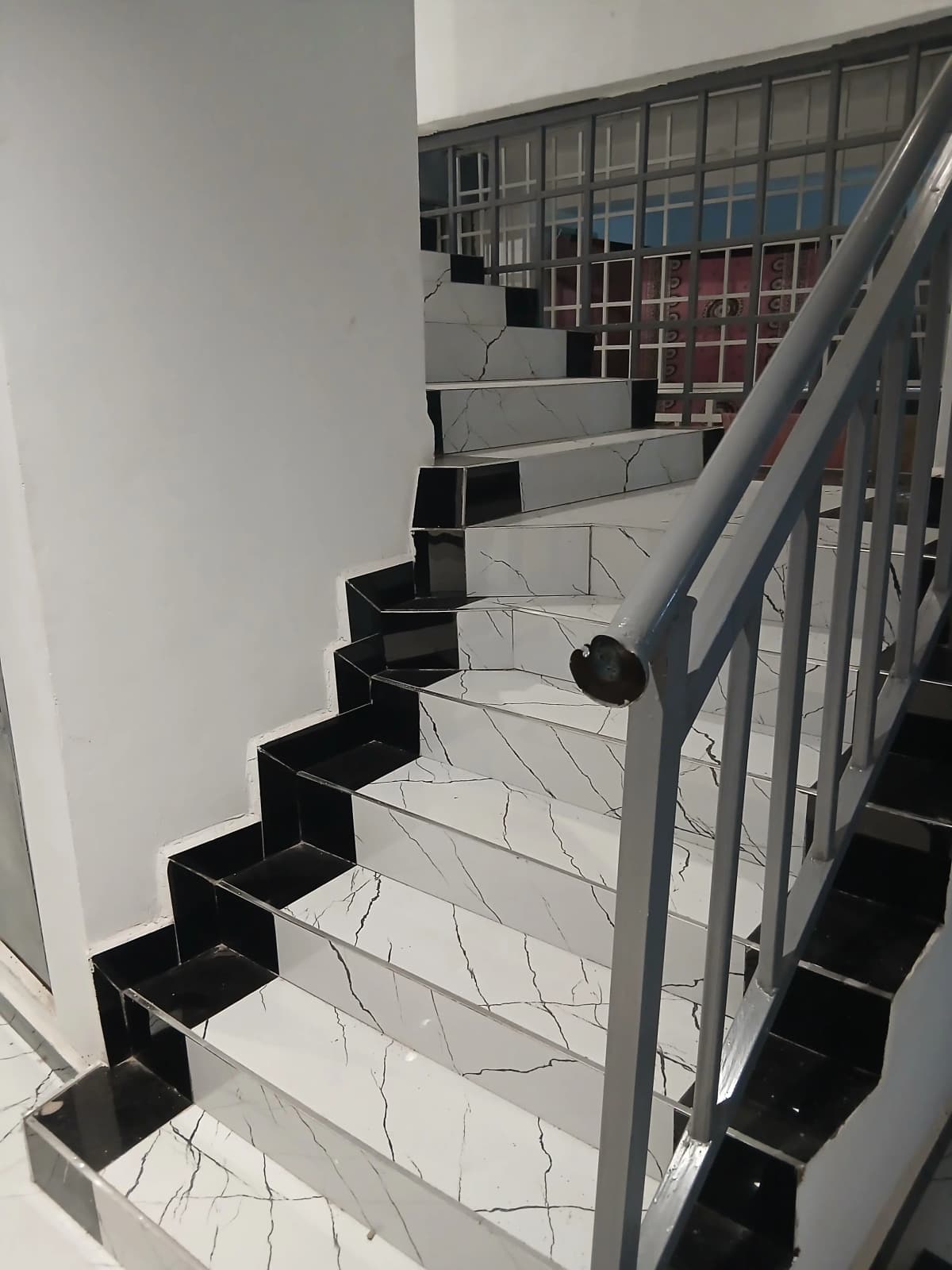 Modern staircase with marble steps and metal railings