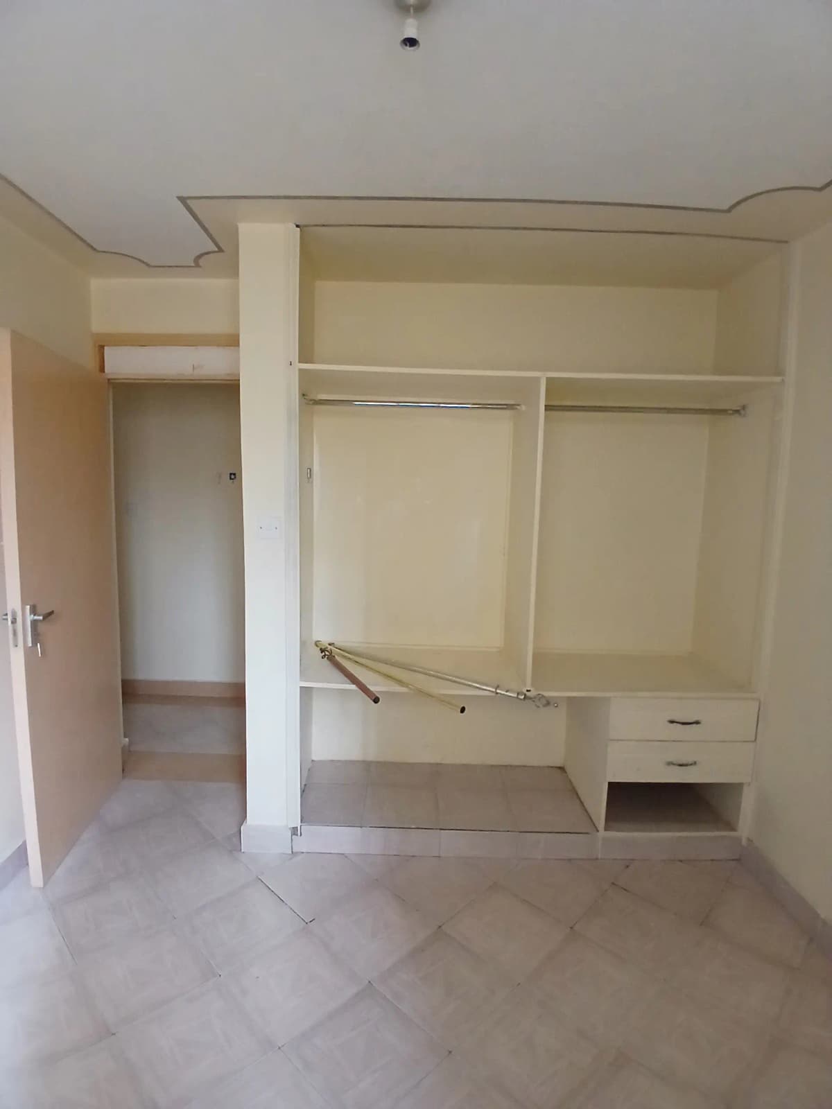 Empty bedroom with built-in wardrobe and open closet space