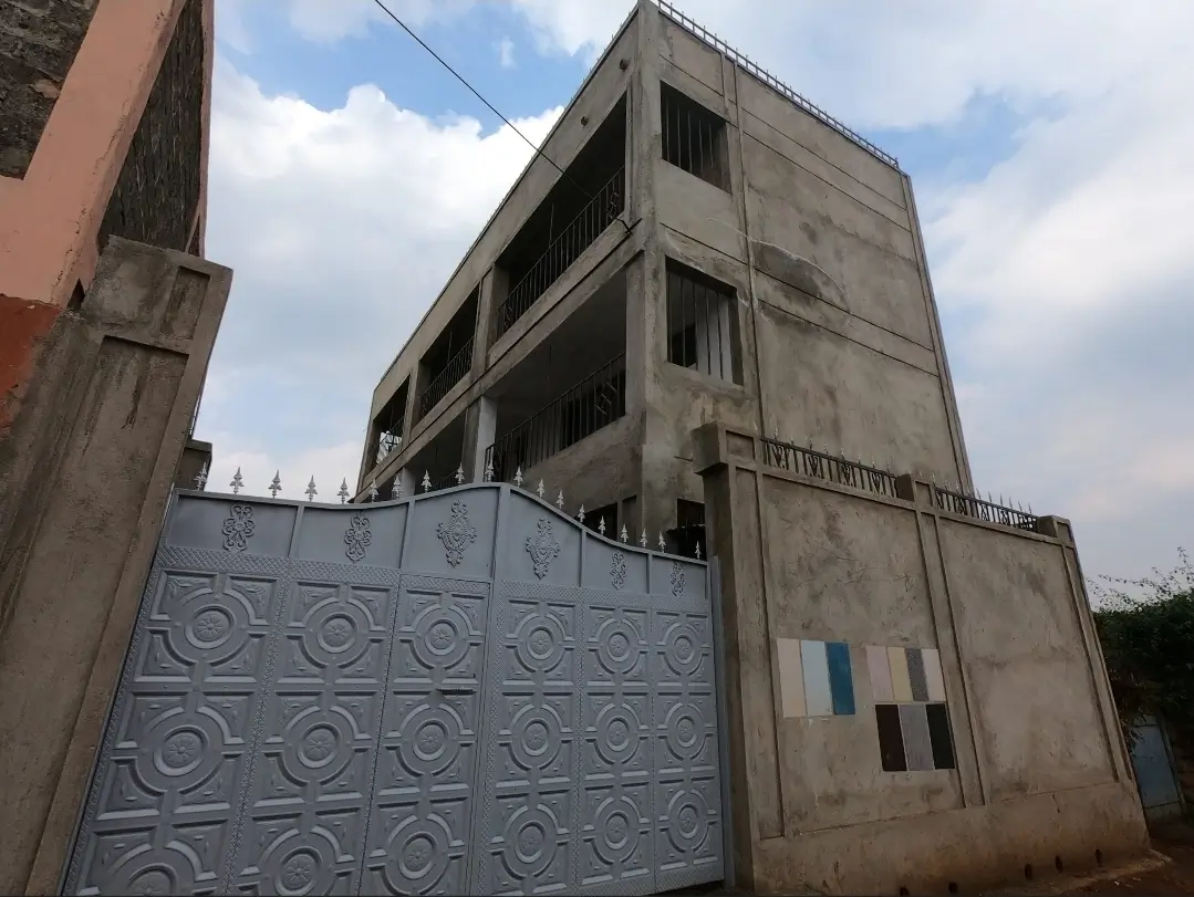 Multi-story concrete building facade with metal gate entrance