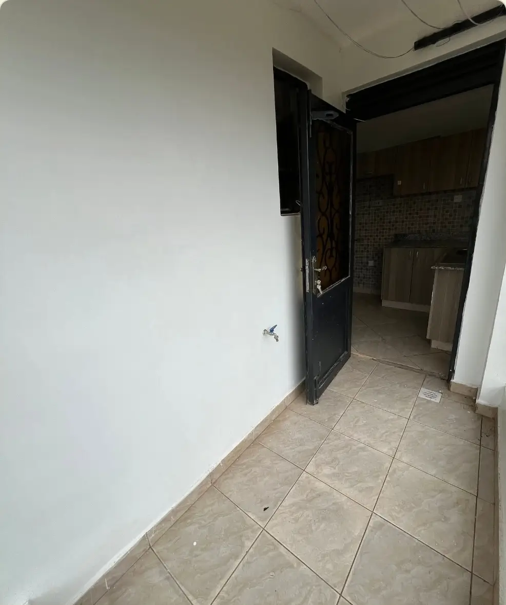 Bathroom entry with tiled floor and dark door