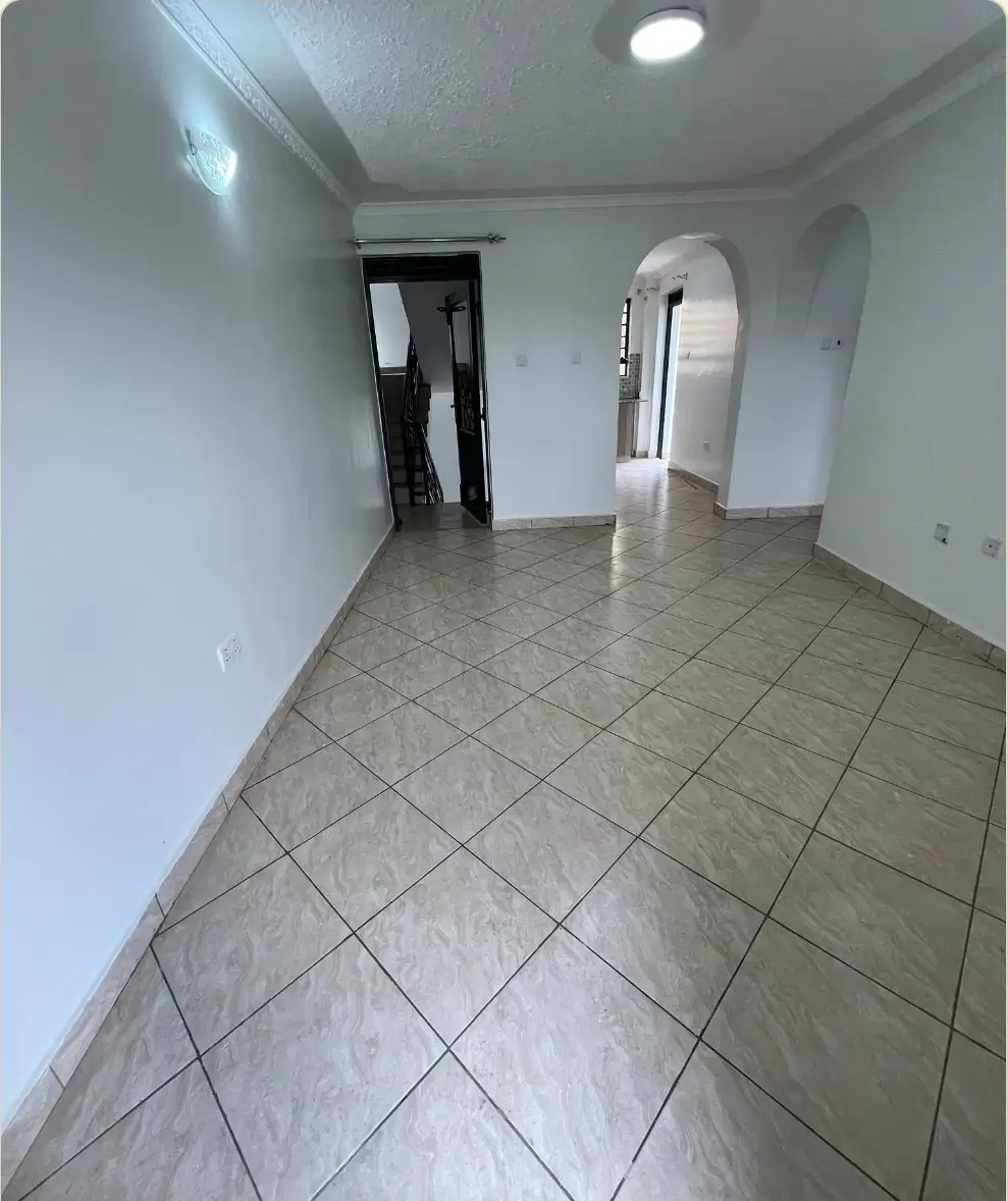 Empty corridor with tiled floor and white walls