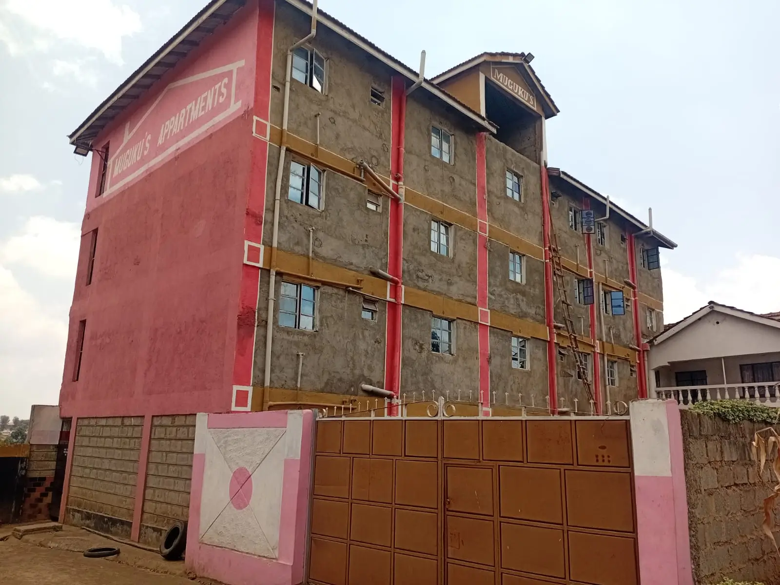 Multi-story residential building facade with red and brown paint