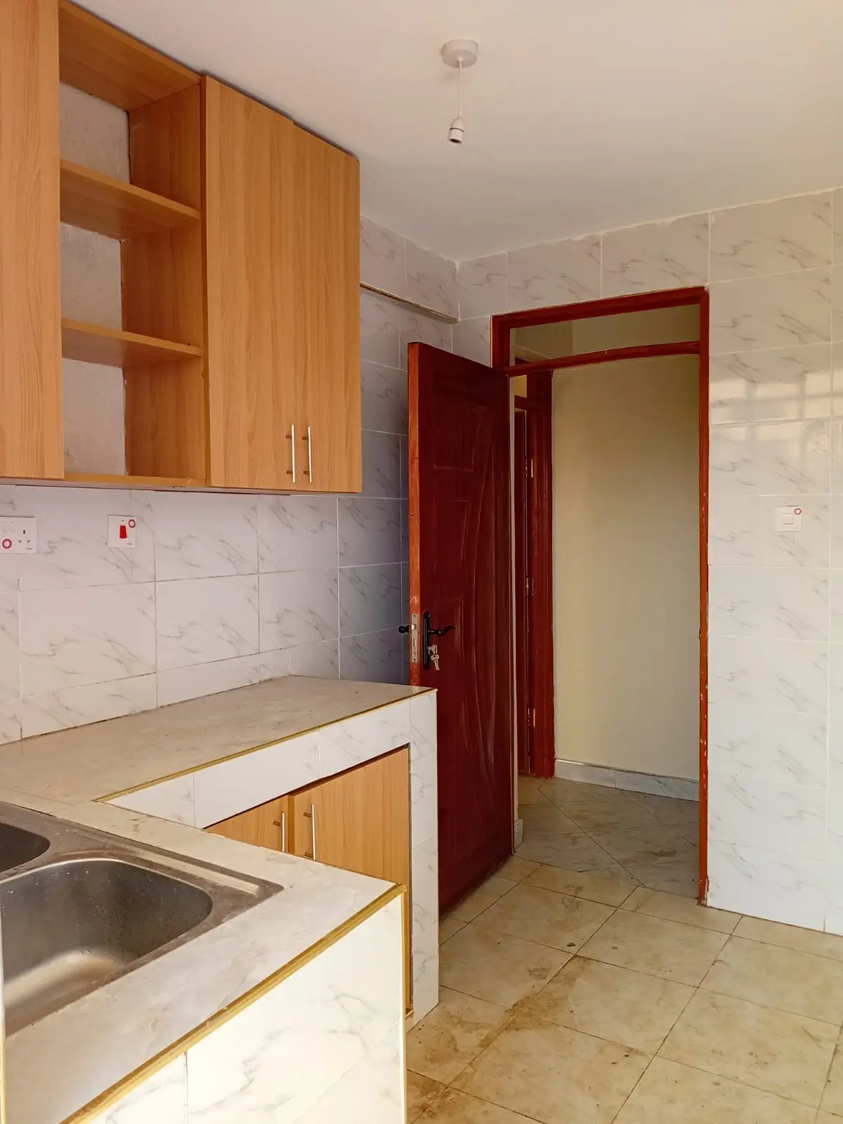 Compact kitchen with wooden cabinets and white tile backsplash
