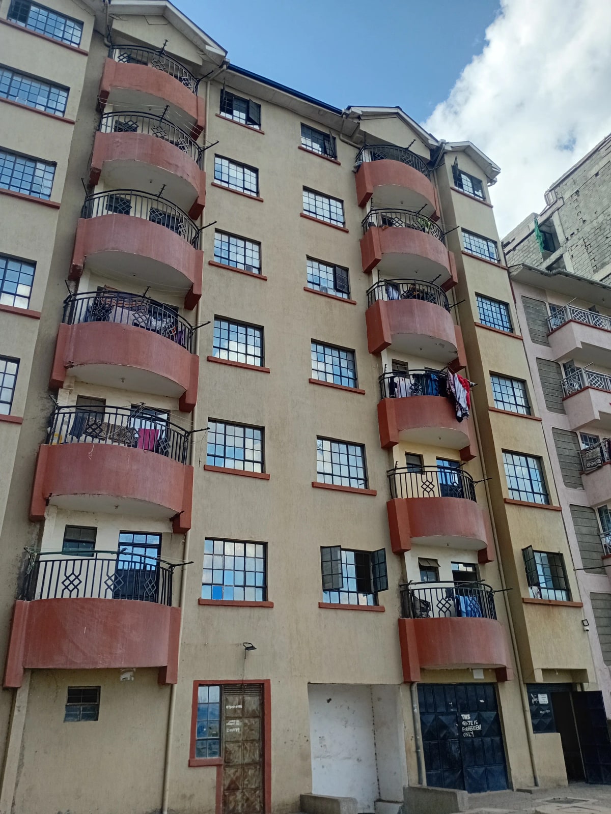 Multi-story residential building facade with red balconies