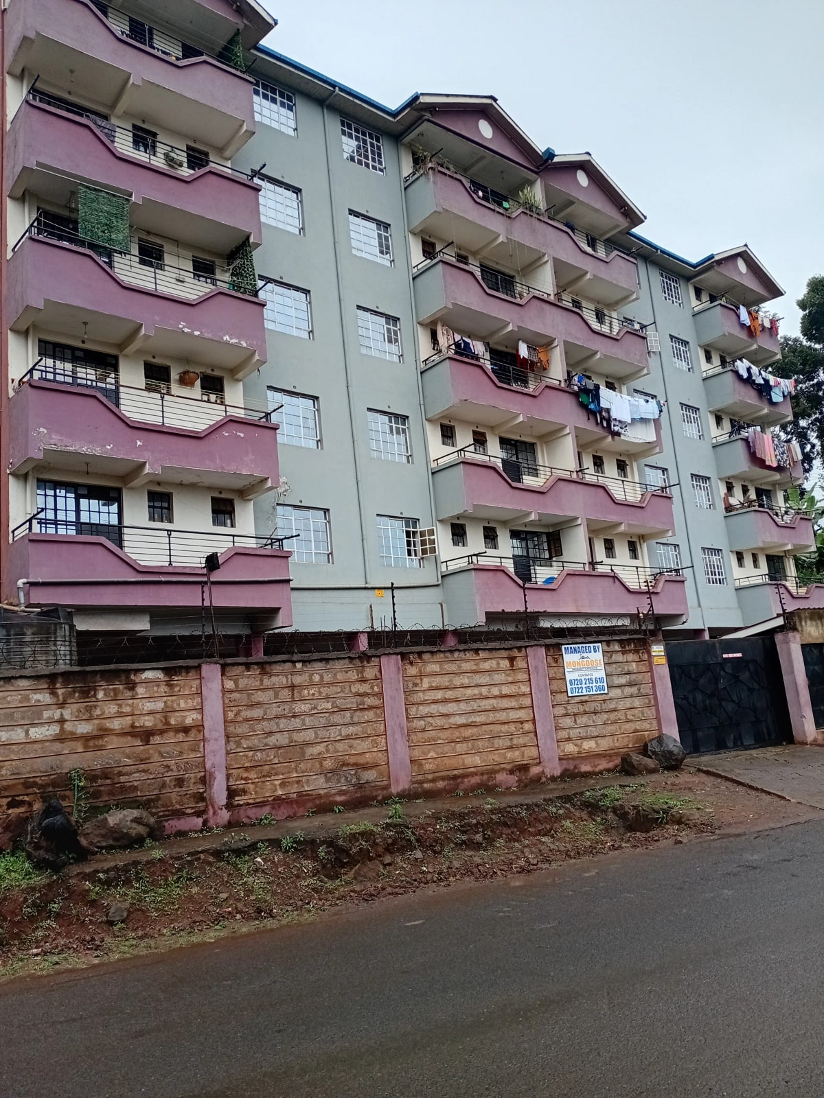 Multi-story residential building with pink and cream facade, balconies