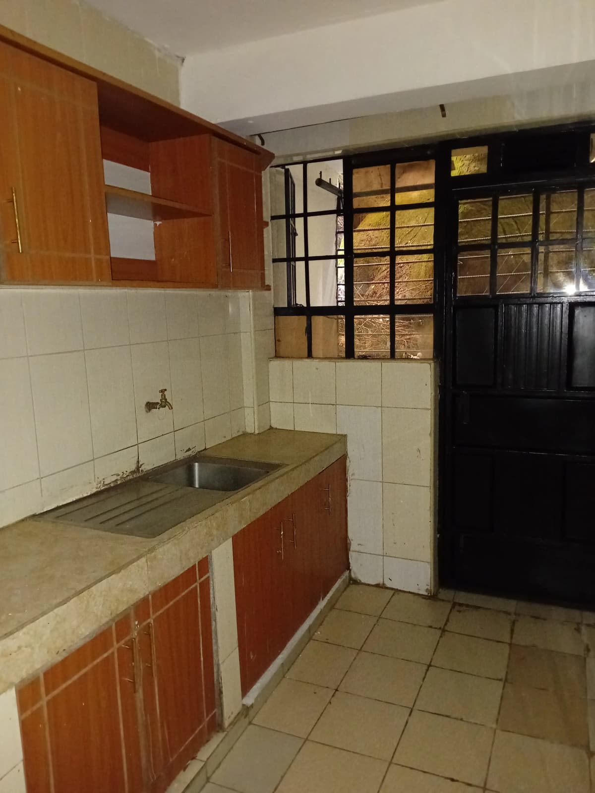 Compact kitchen with wooden cabinets and white tile backsplash