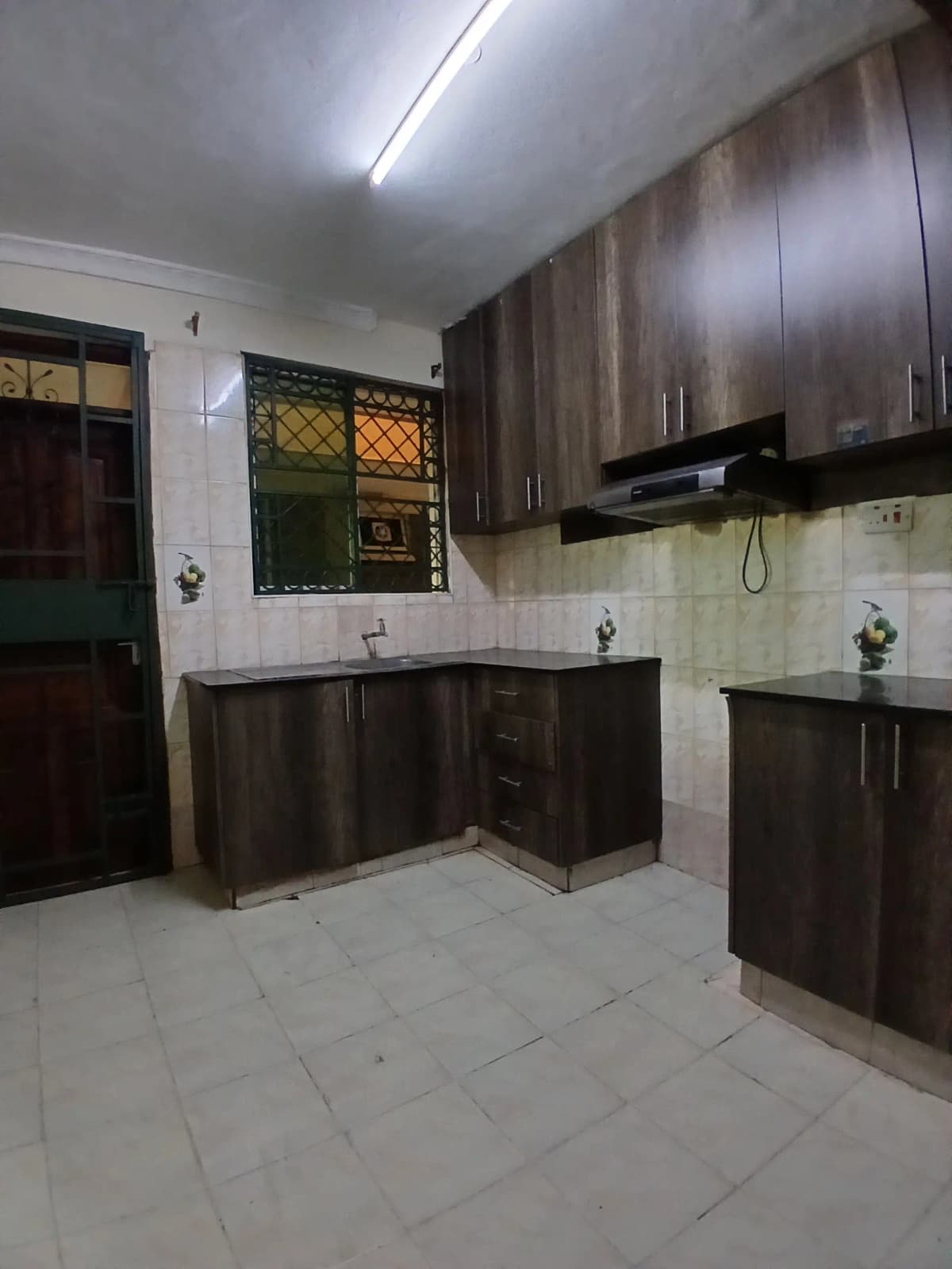 Spacious kitchen with dark cabinetry and tiled flooring