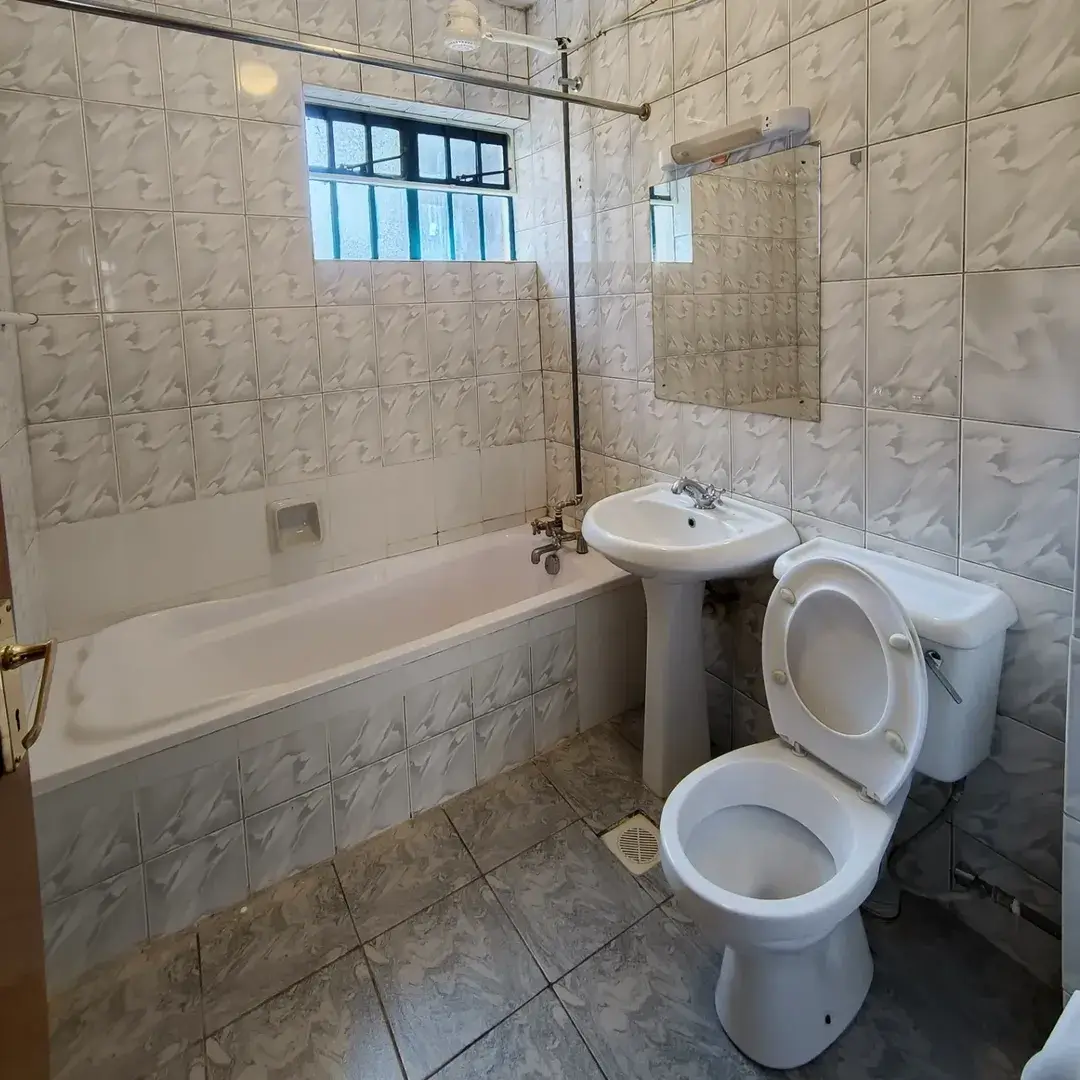 Spacious bathroom with bathtub, dual toilets, sink and shower