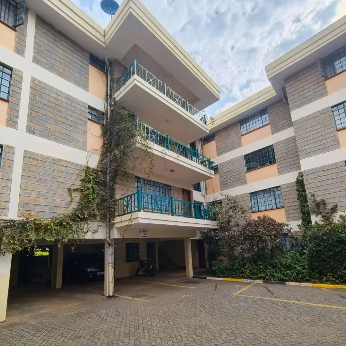Multi-story residential building with covered parking entrance.