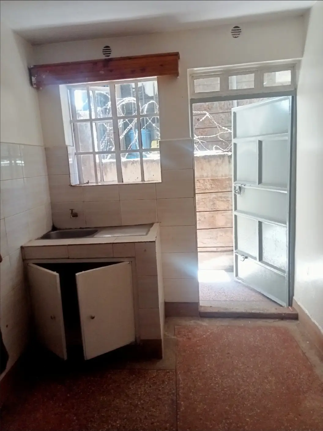 Compact kitchen with built-in counter and glass door access