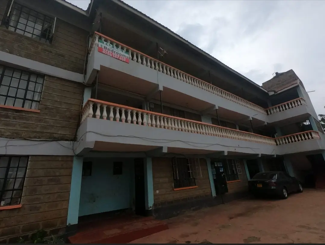 Multi-story residential building with balconies and ground-level shops
