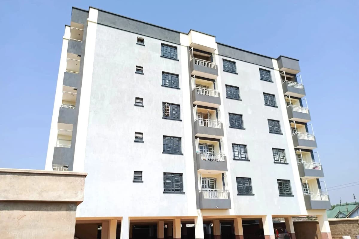 Modern multi-story residential building with balconies and parking