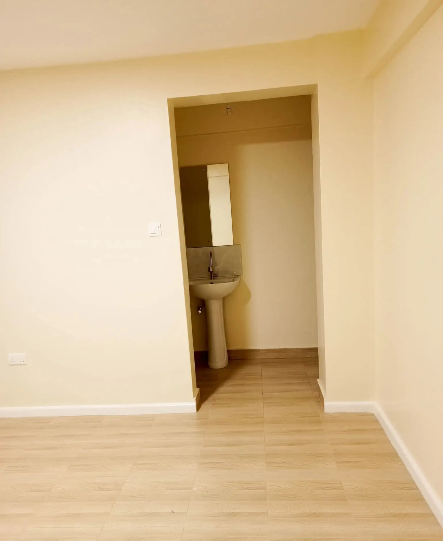 Spacious bedroom with ensuite bathroom visible through doorway