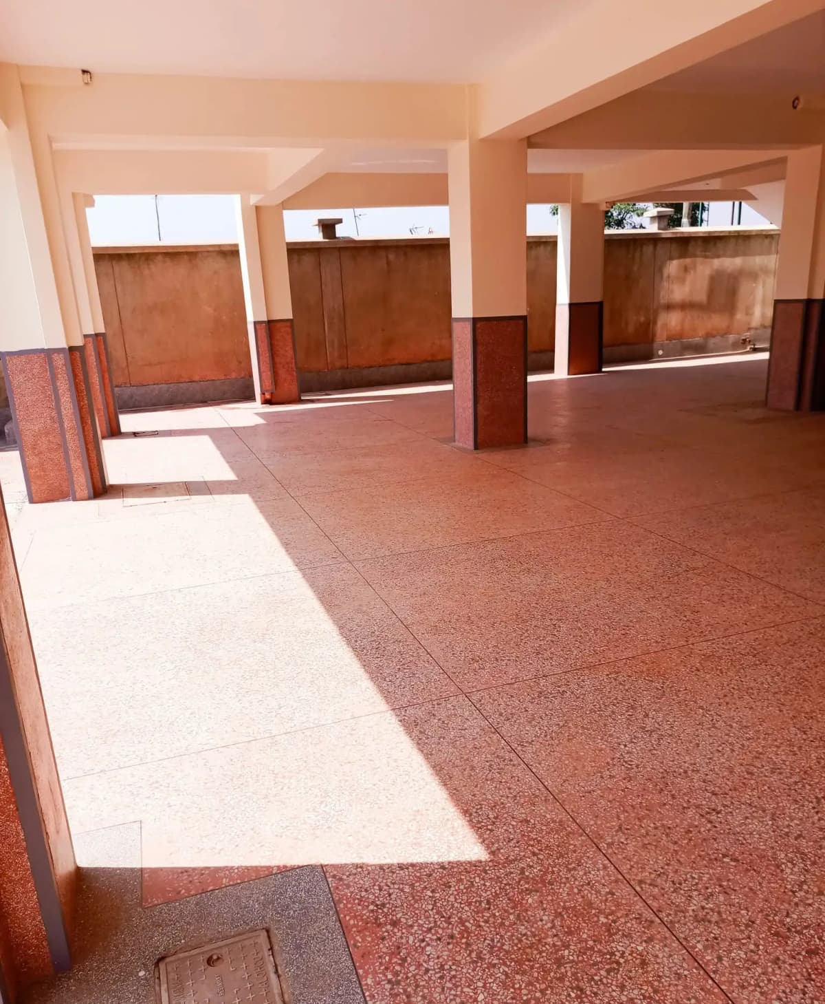 Spacious building lobby with polished terrazzo flooring and wooden doors