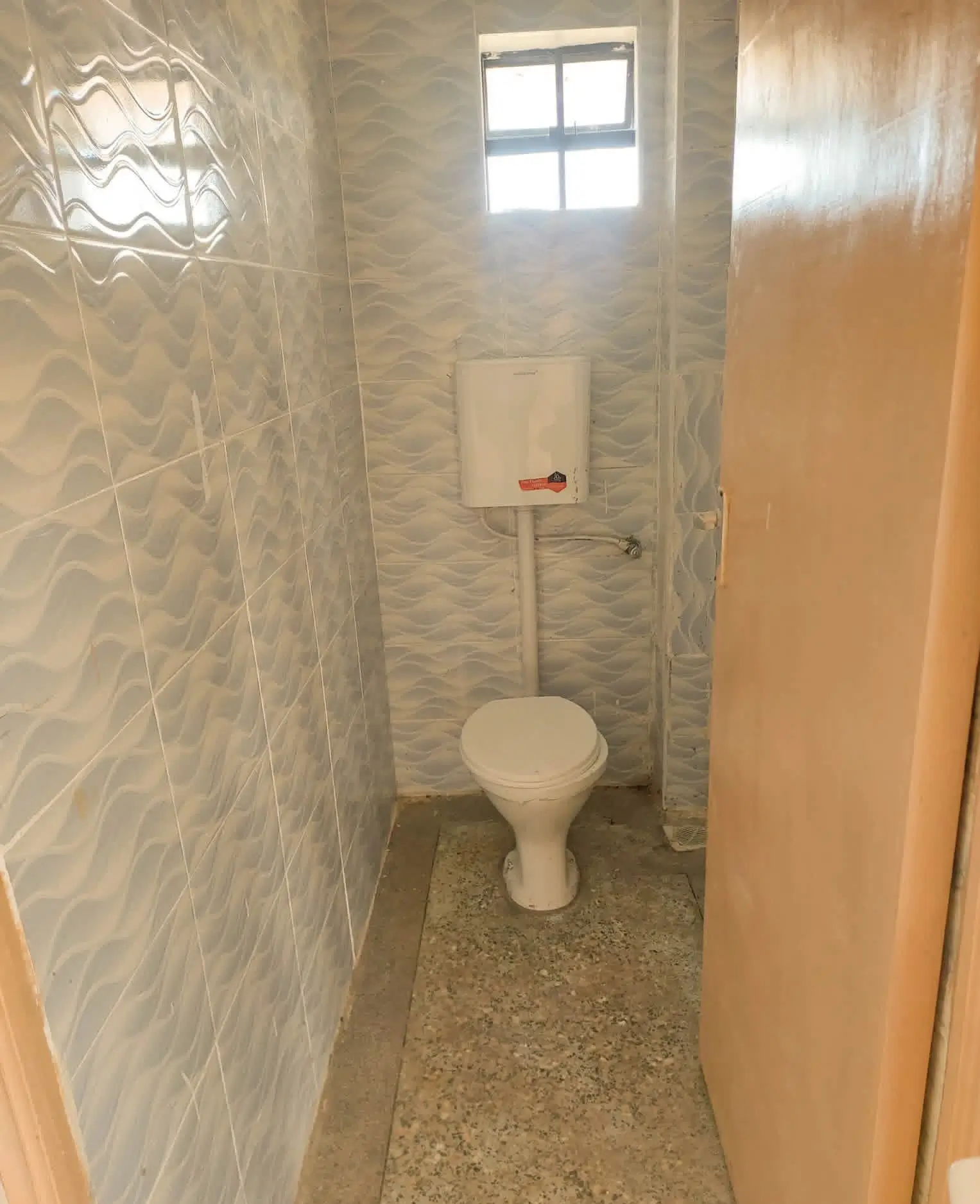 Compact bathroom with ceramic tile walls and toilet