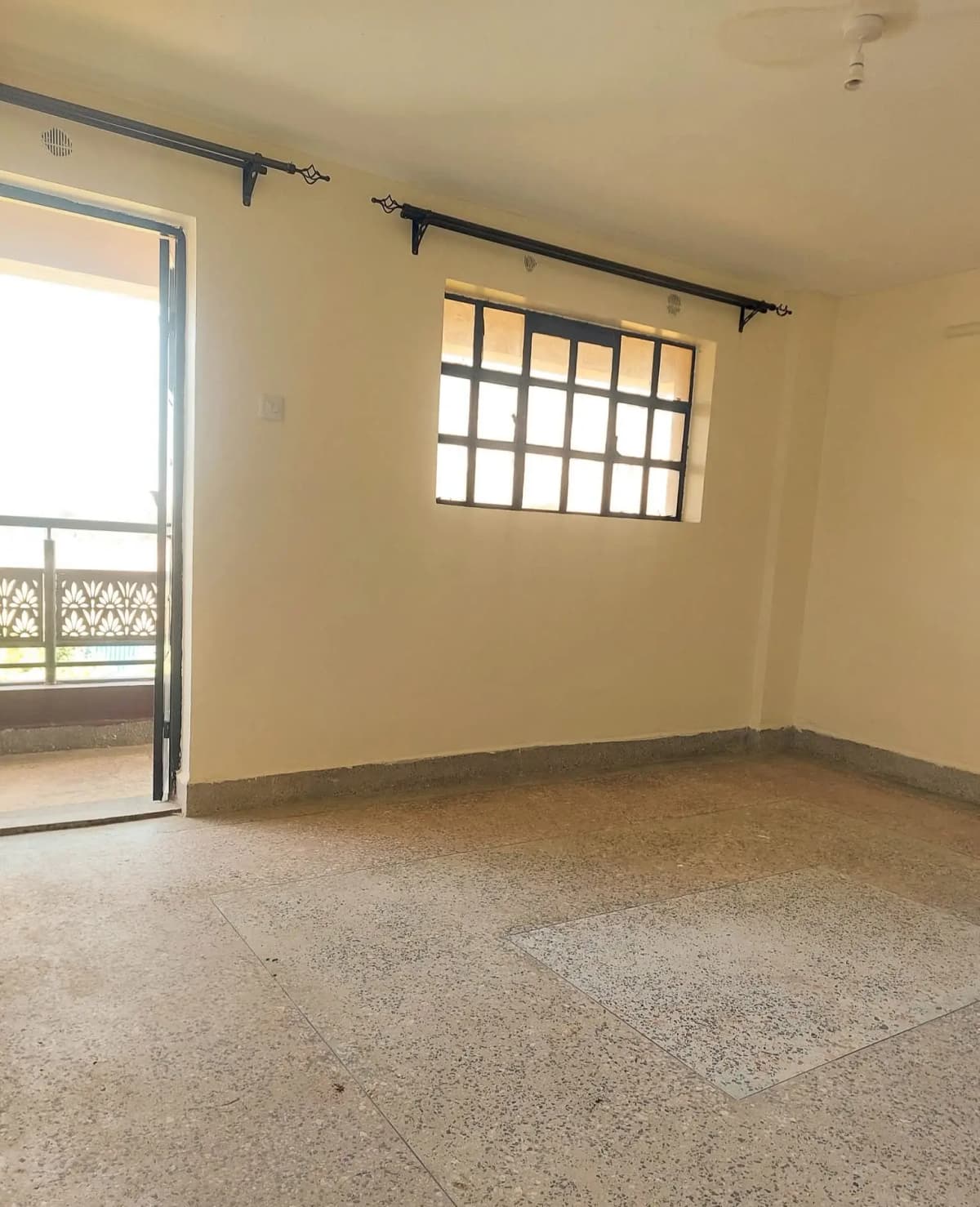 Empty living room with concrete flooring and balcony access