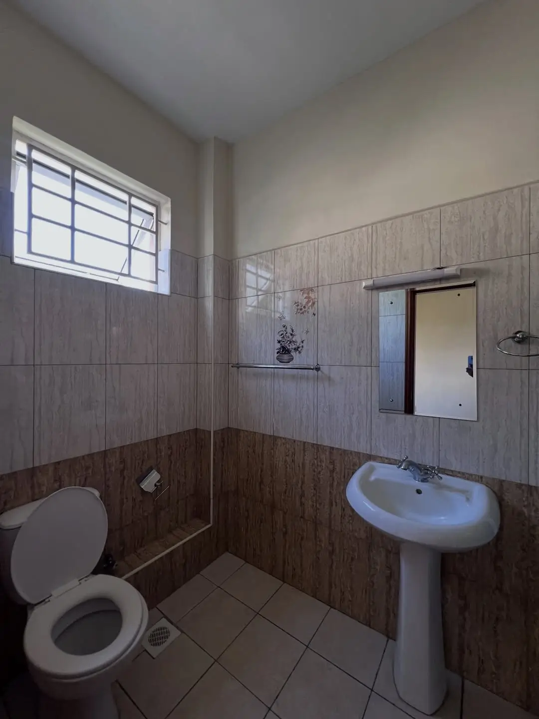 Compact bathroom with pedestal sink, toilet, and tiled walls