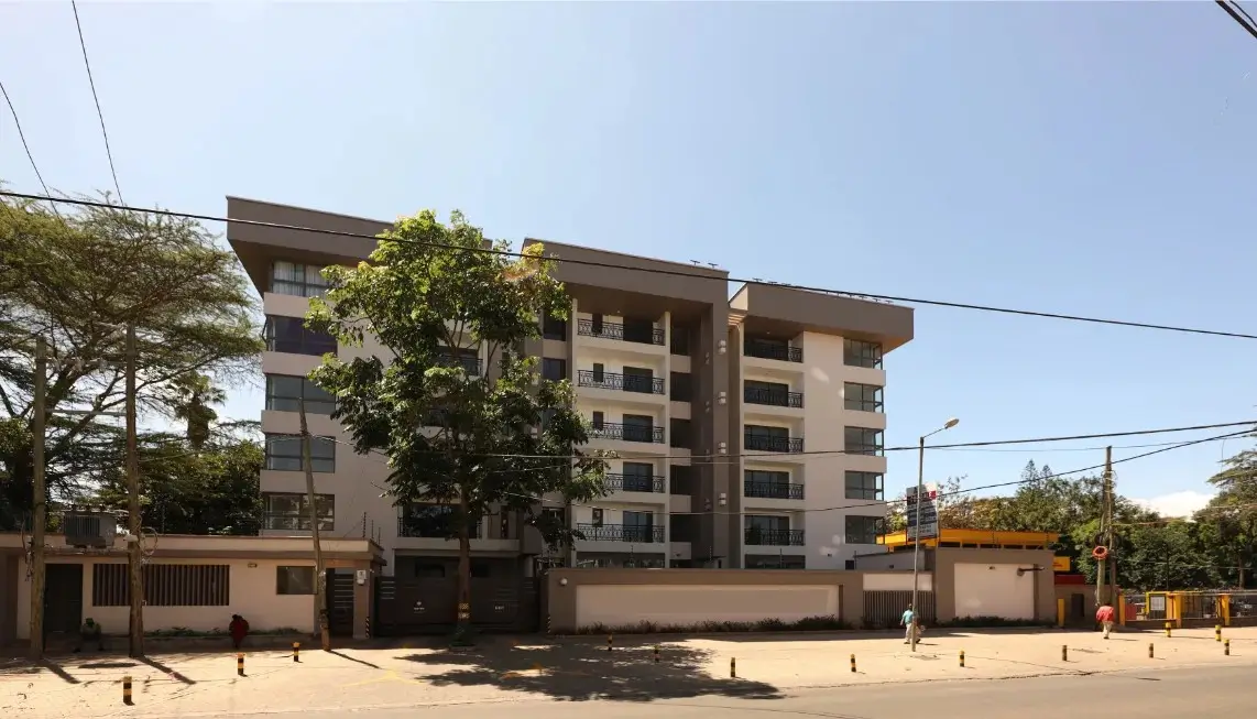Modern multi-story residential building with compound perimeter wall