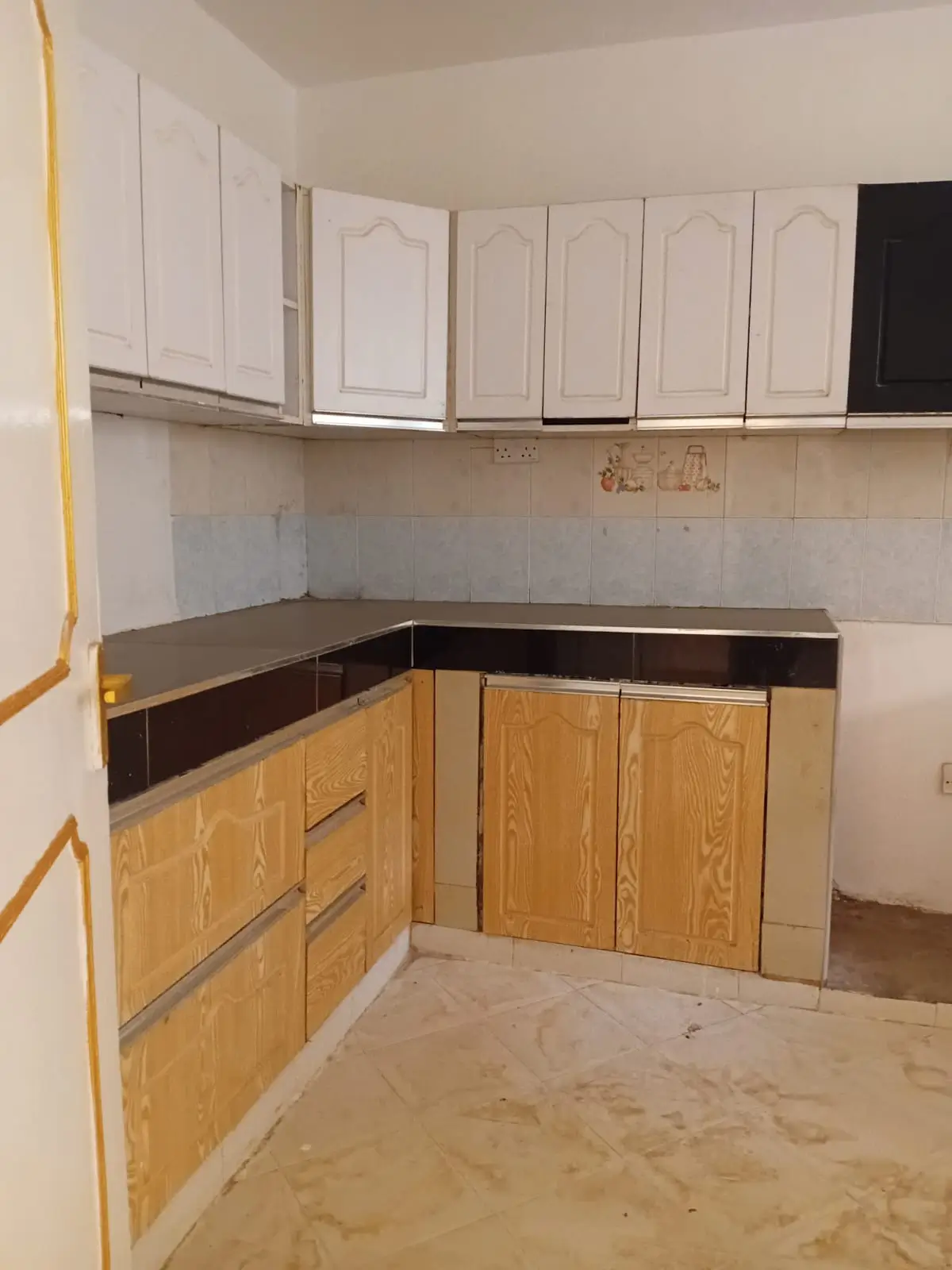 L-shaped kitchen with white upper cabinets, wooden lower units