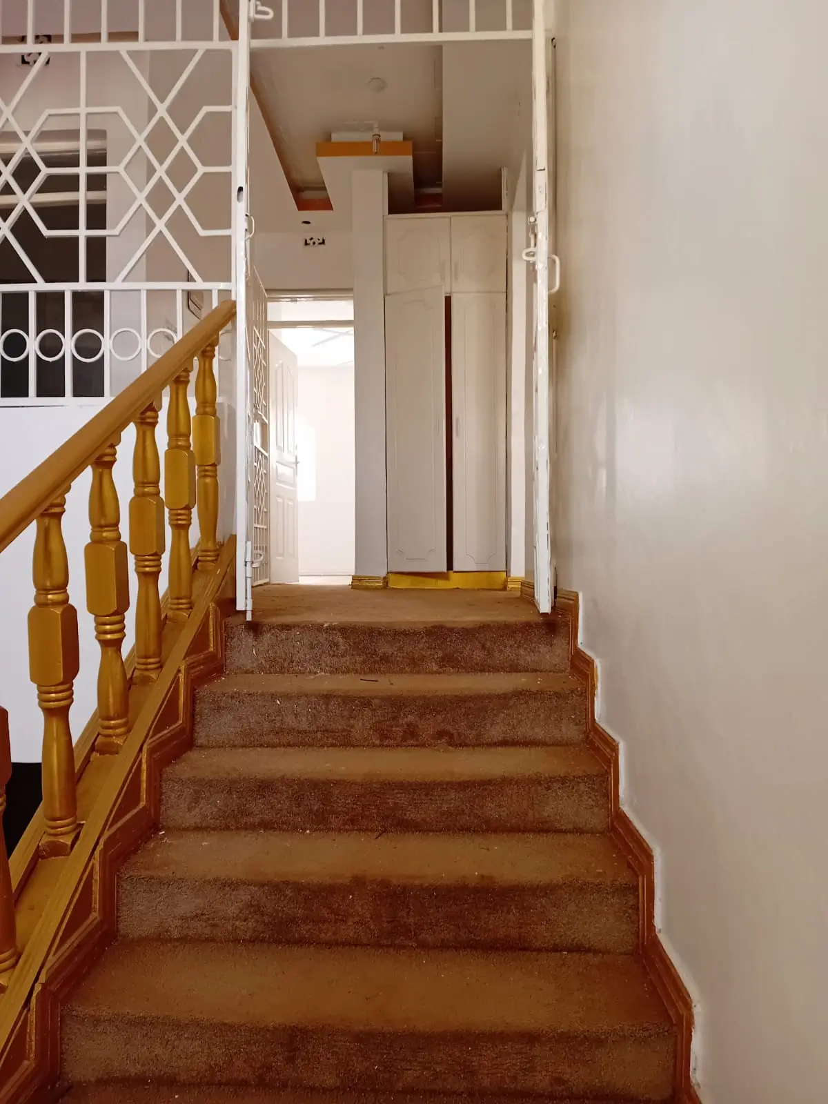 Interior staircase with wooden railing and elevator doors
