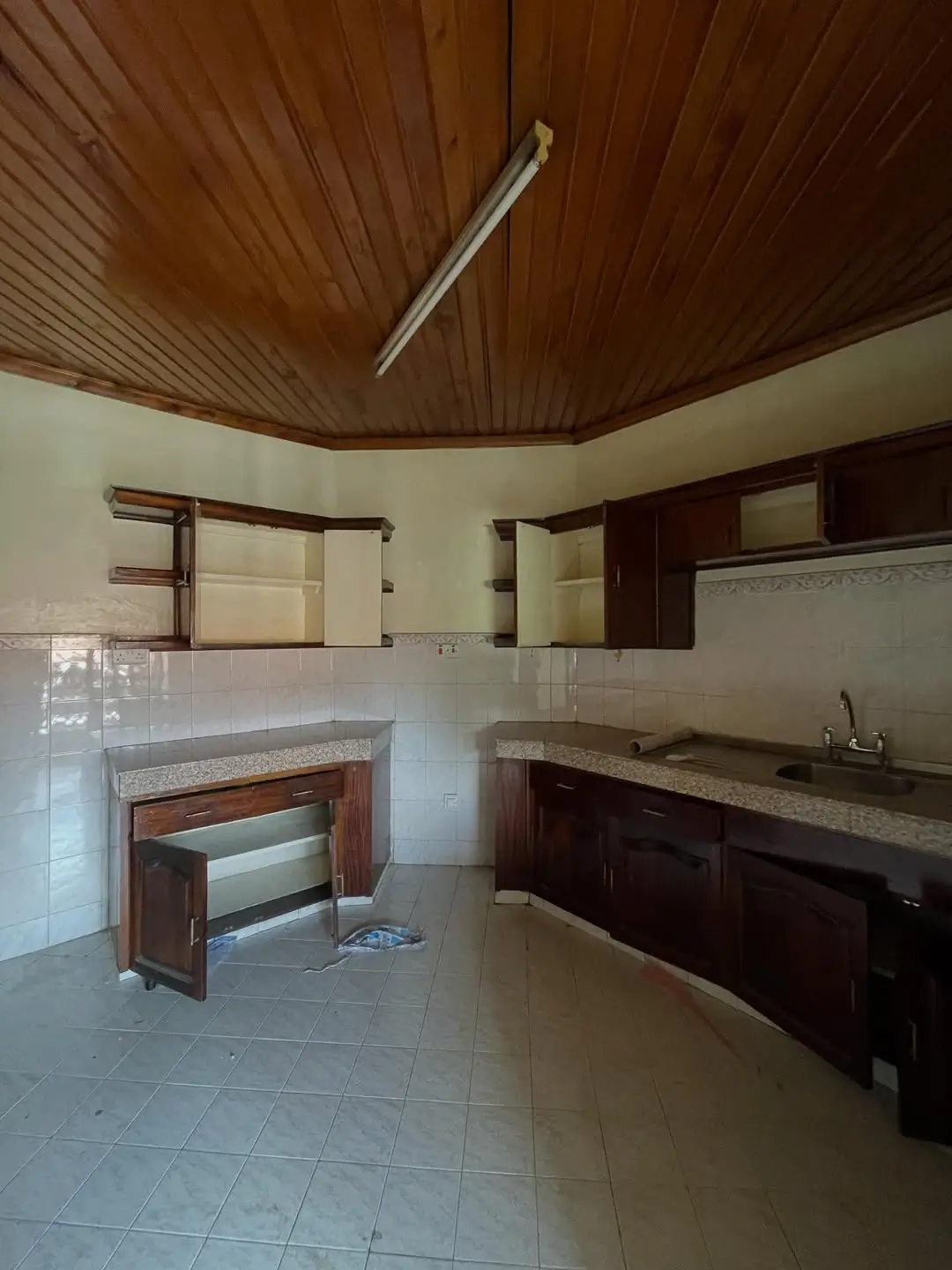 Spacious kitchen with wooden ceiling and dark cabinetry