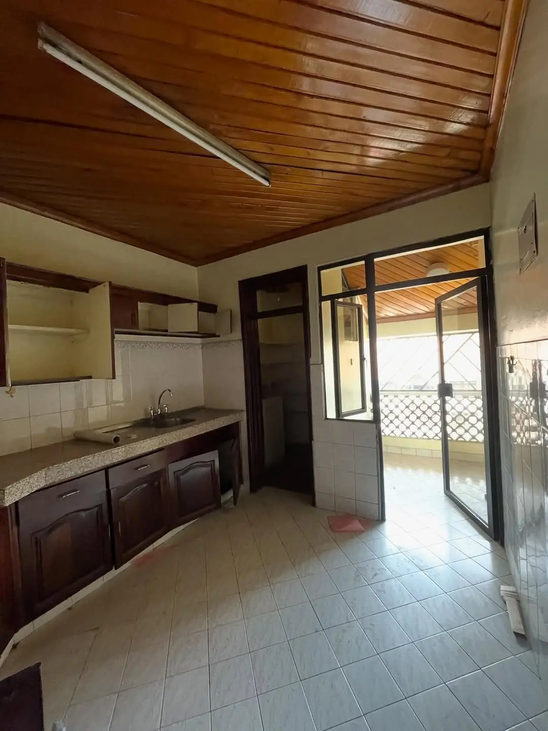 Kitchen with wooden ceiling and glass door to balcony