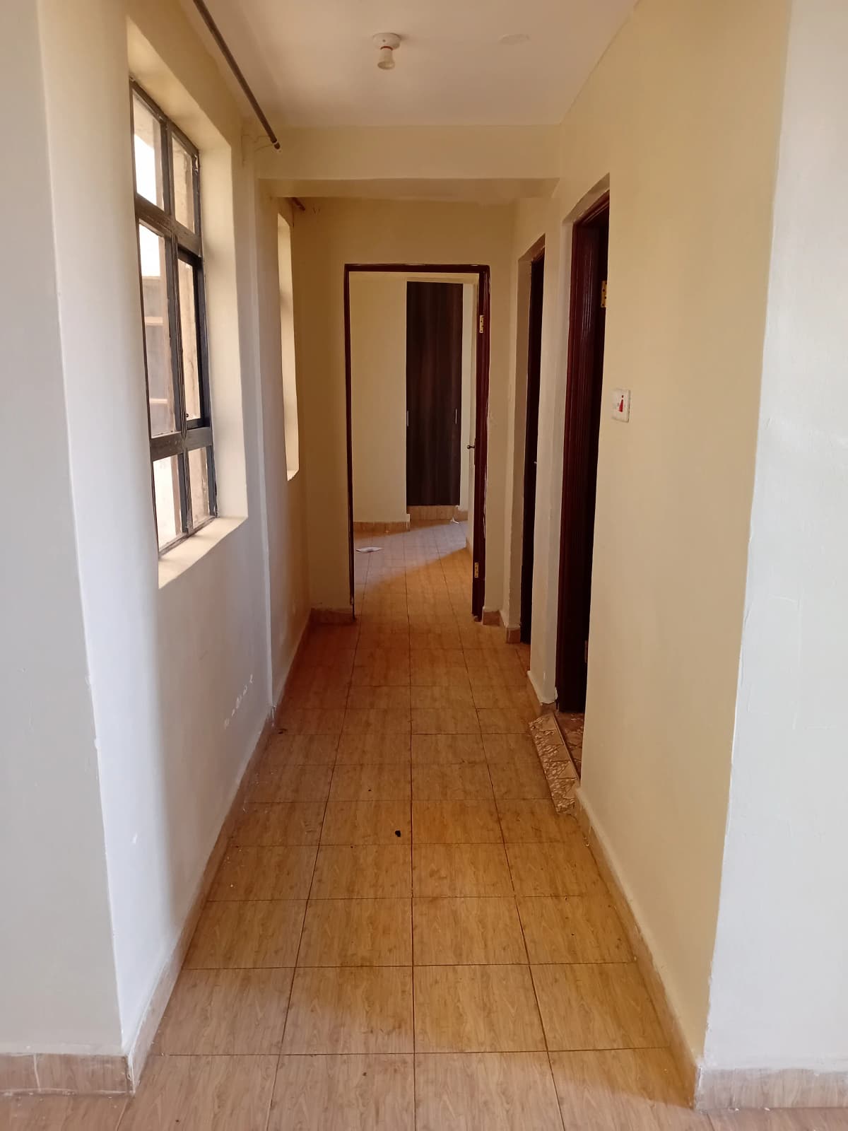Long corridor with wooden flooring and multiple doorways