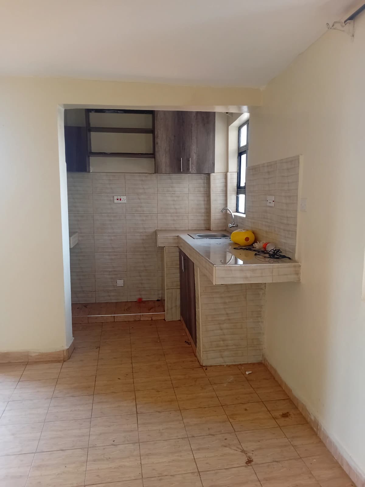 Compact kitchen with beige cabinetry and counter space
