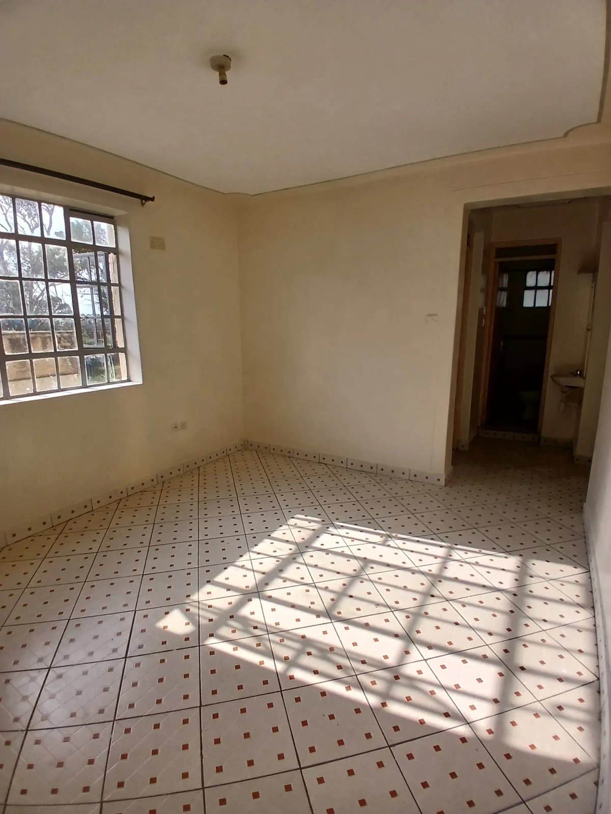 Spacious living room with patterned tile floor and natural light