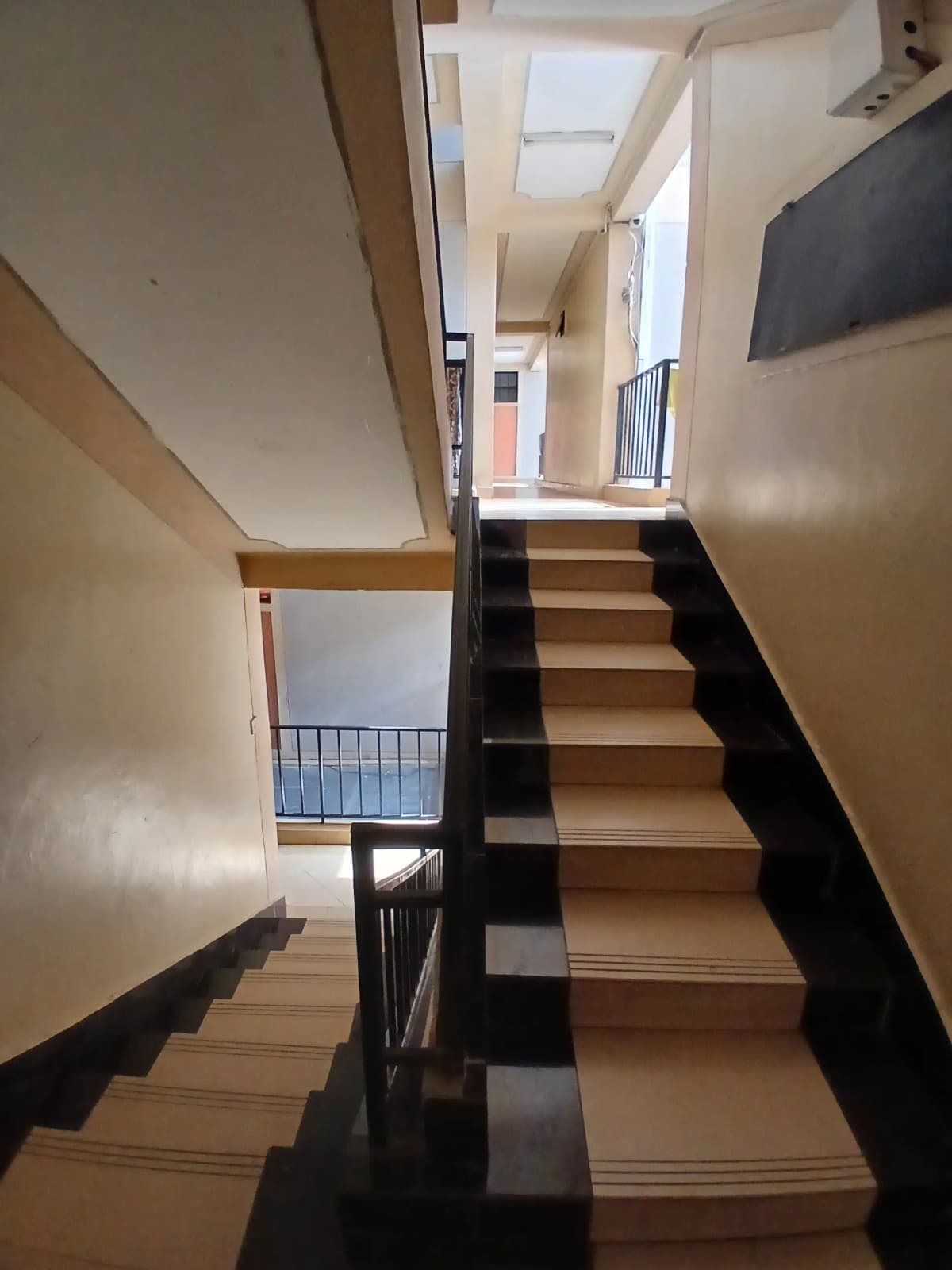 Interior staircase with black railings and wooden steps