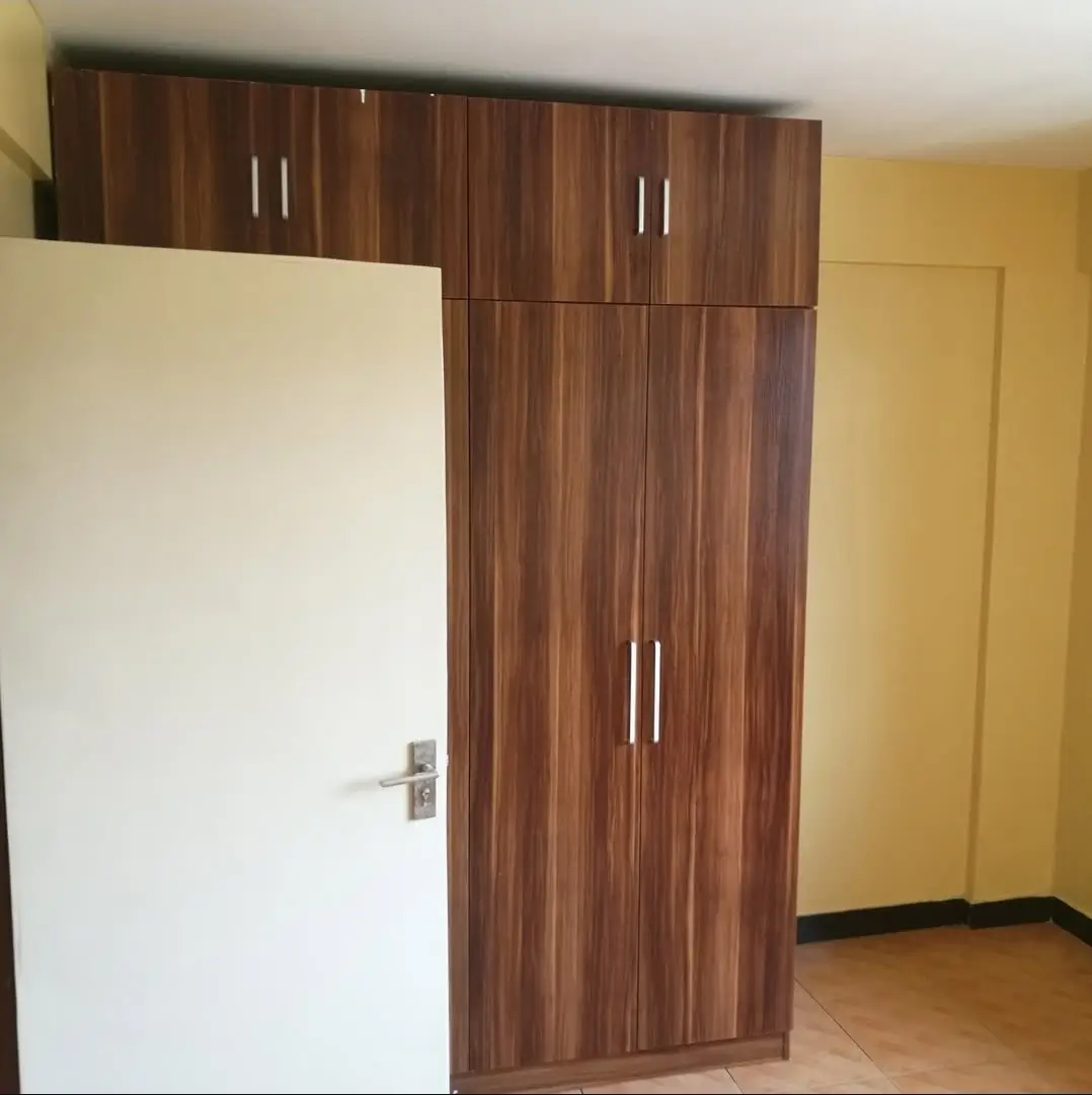 Bedroom with built-in wooden wardrobes and yellow walls