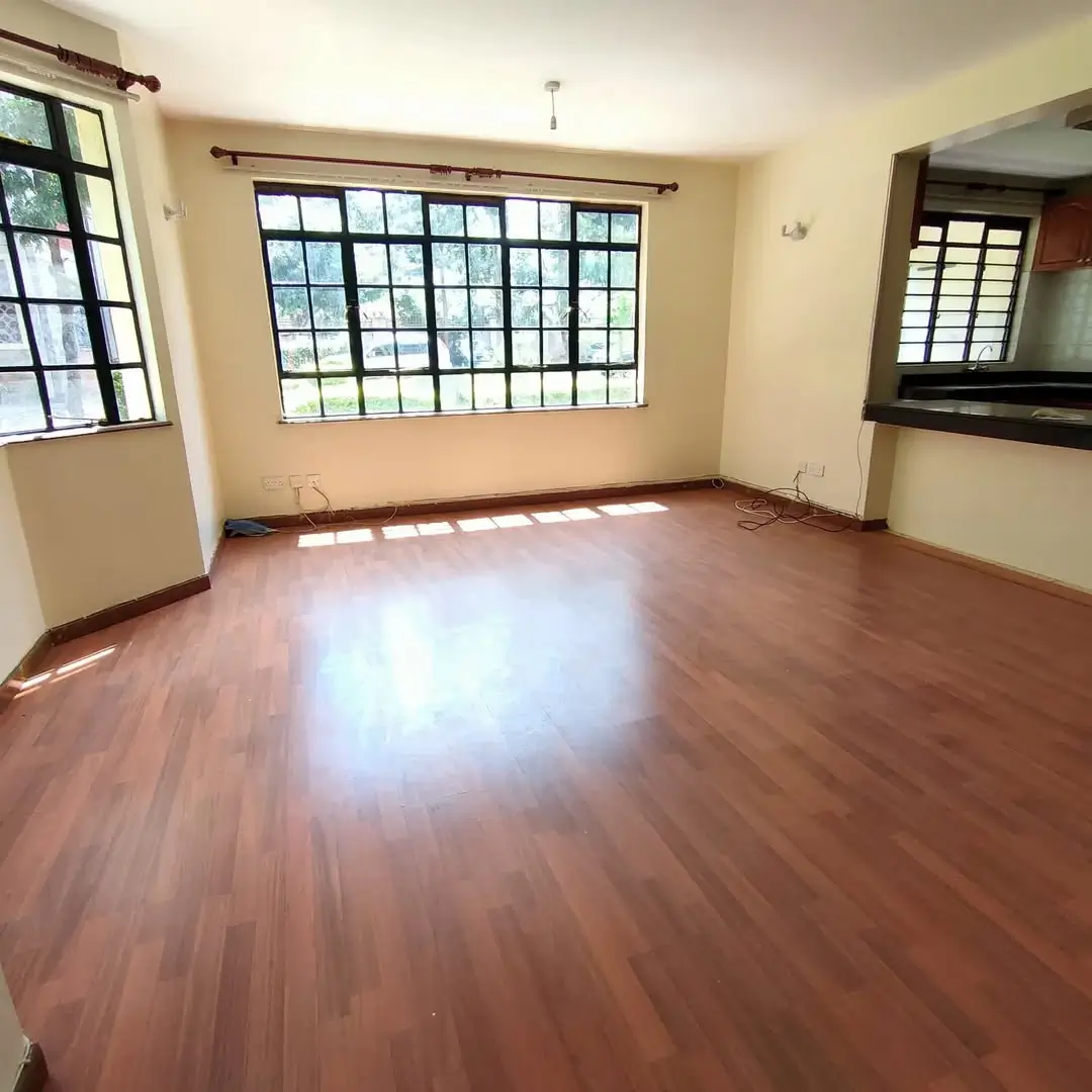 Spacious living room with polished wooden floors and natural light