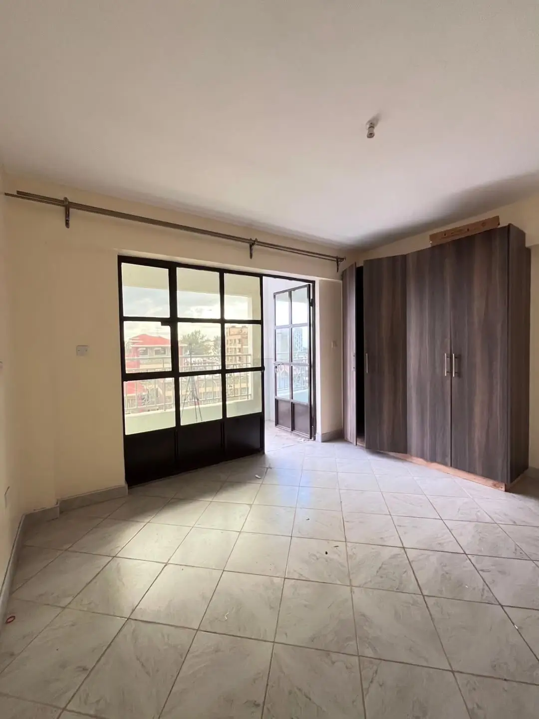Spacious bedroom with balcony access and built-in wardrobes