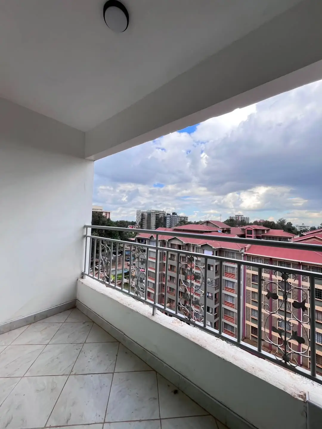 Covered balcony with city skyline and cloudy sky view