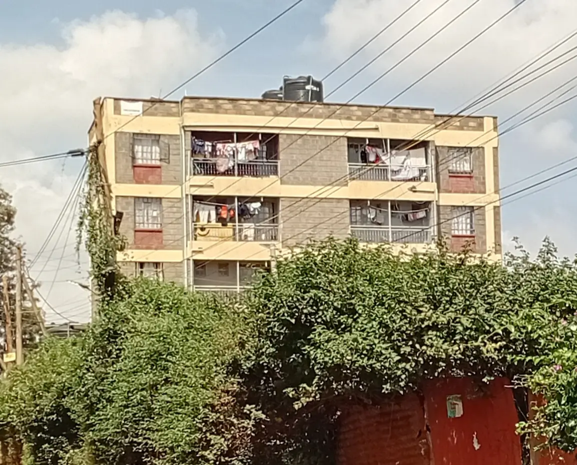 Multi-story residential building facade with balconies and greenery