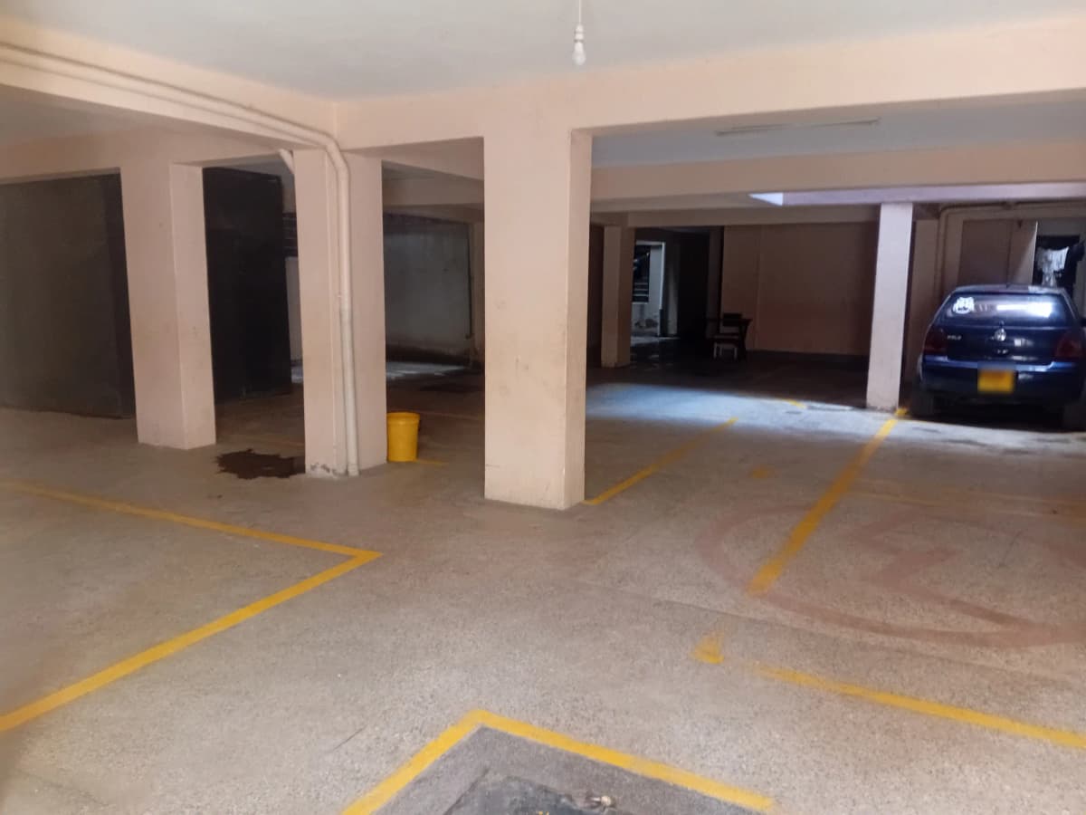 Underground parking garage with marked bays and blue car