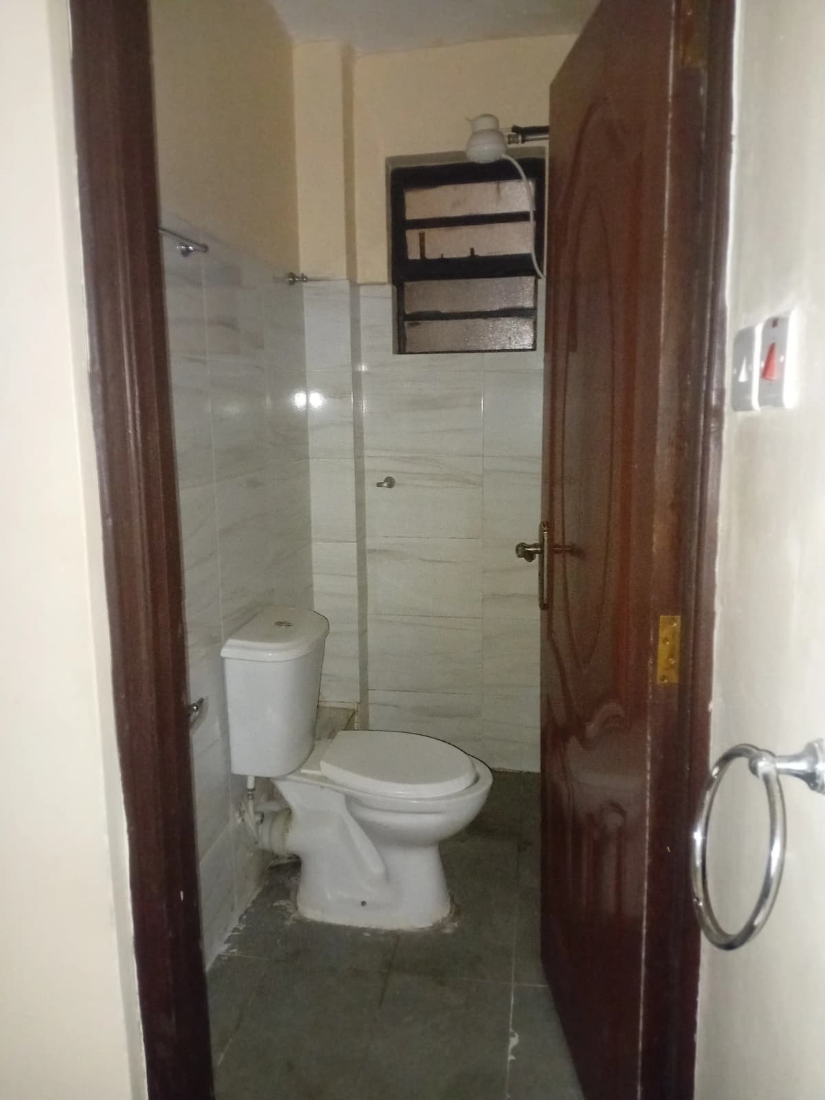 Compact bathroom with toilet, basin, and shower enclosure.