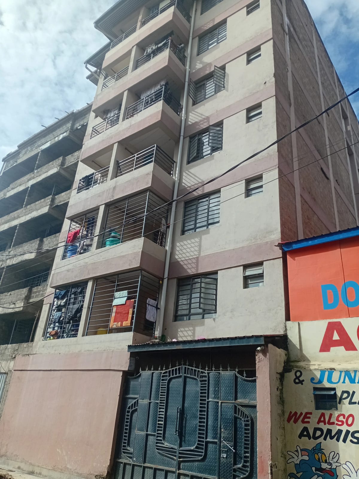 Multi-story residential building facade with street-level parking.