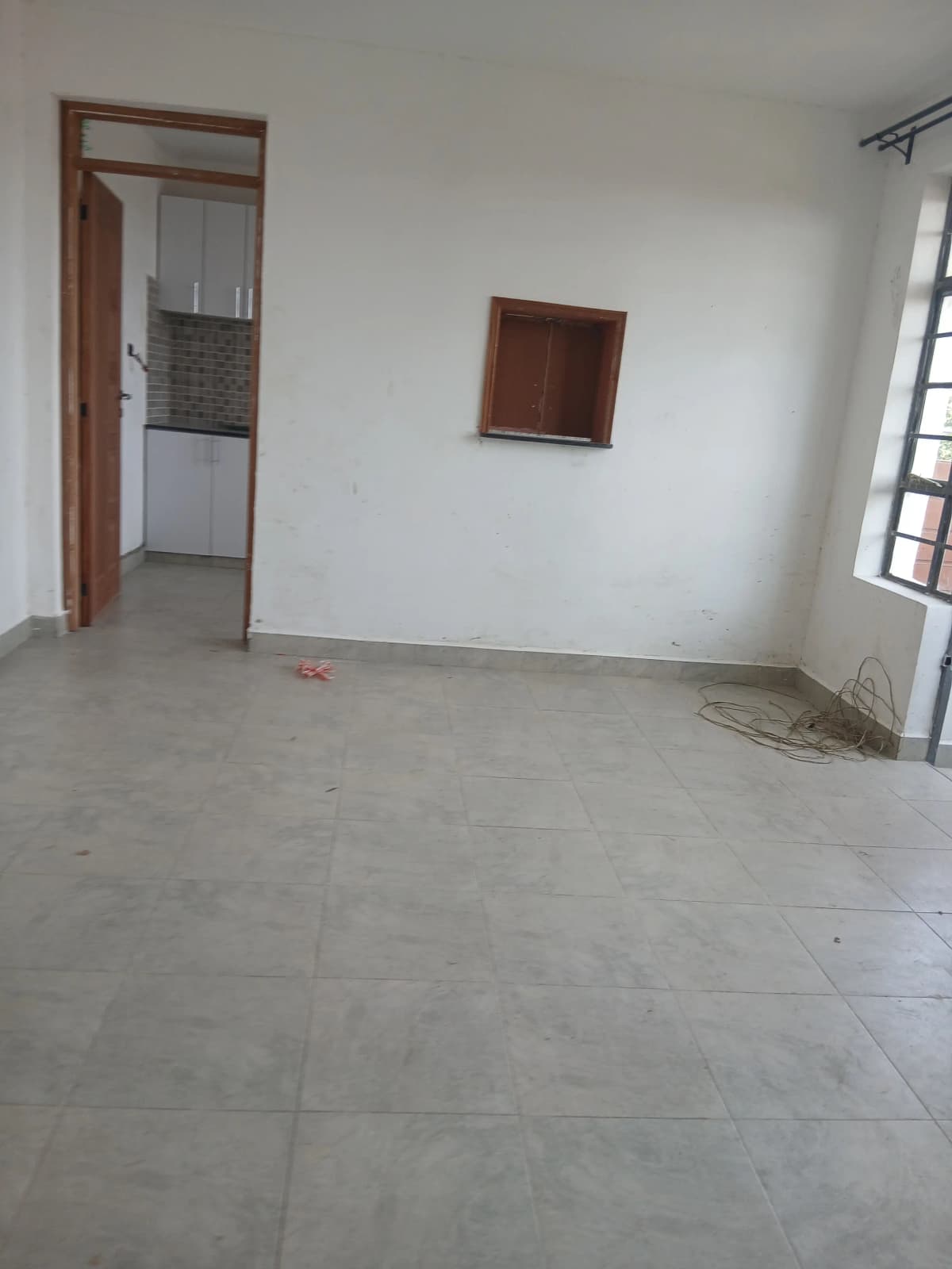 Open-plan living area with kitchen visible through doorway