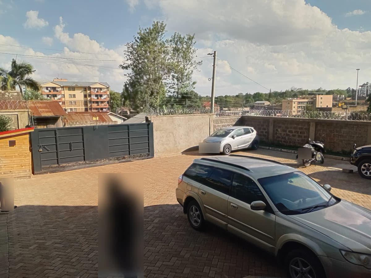 Covered parking bay with multiple vehicles in residential compound