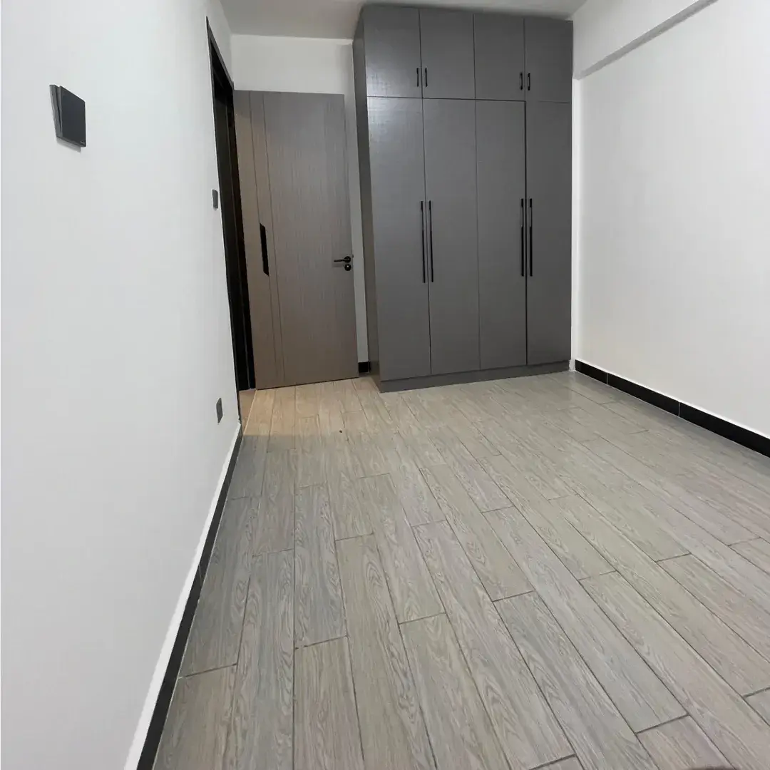 Empty bedroom with gray wardrobe and laminate flooring